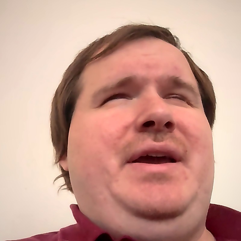Tony Gebhard — a man with short brown hair and a trimmed beard, wearing a maroon polo shirt.